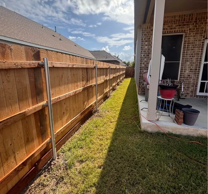 Backyard wood fence installation with metal posts